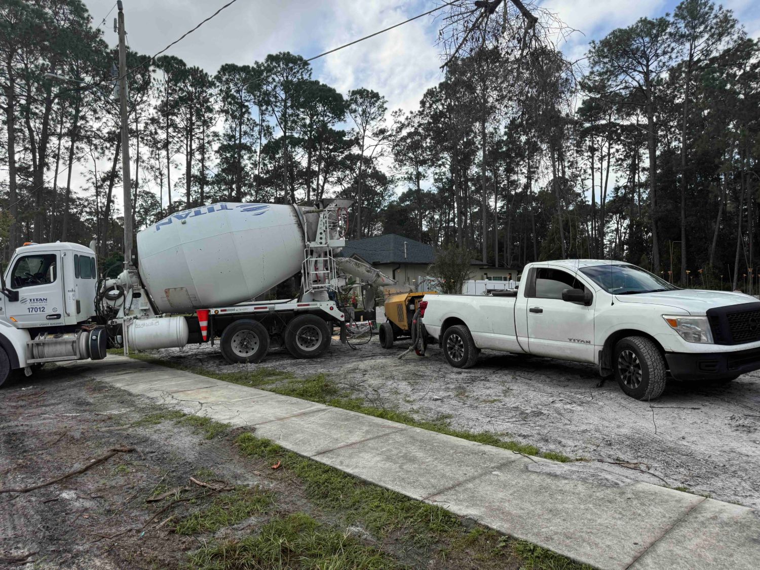 Titan Concrete mixer truck and a concrete pump at the Captain Drive lot, filling the stem wall cells and footers